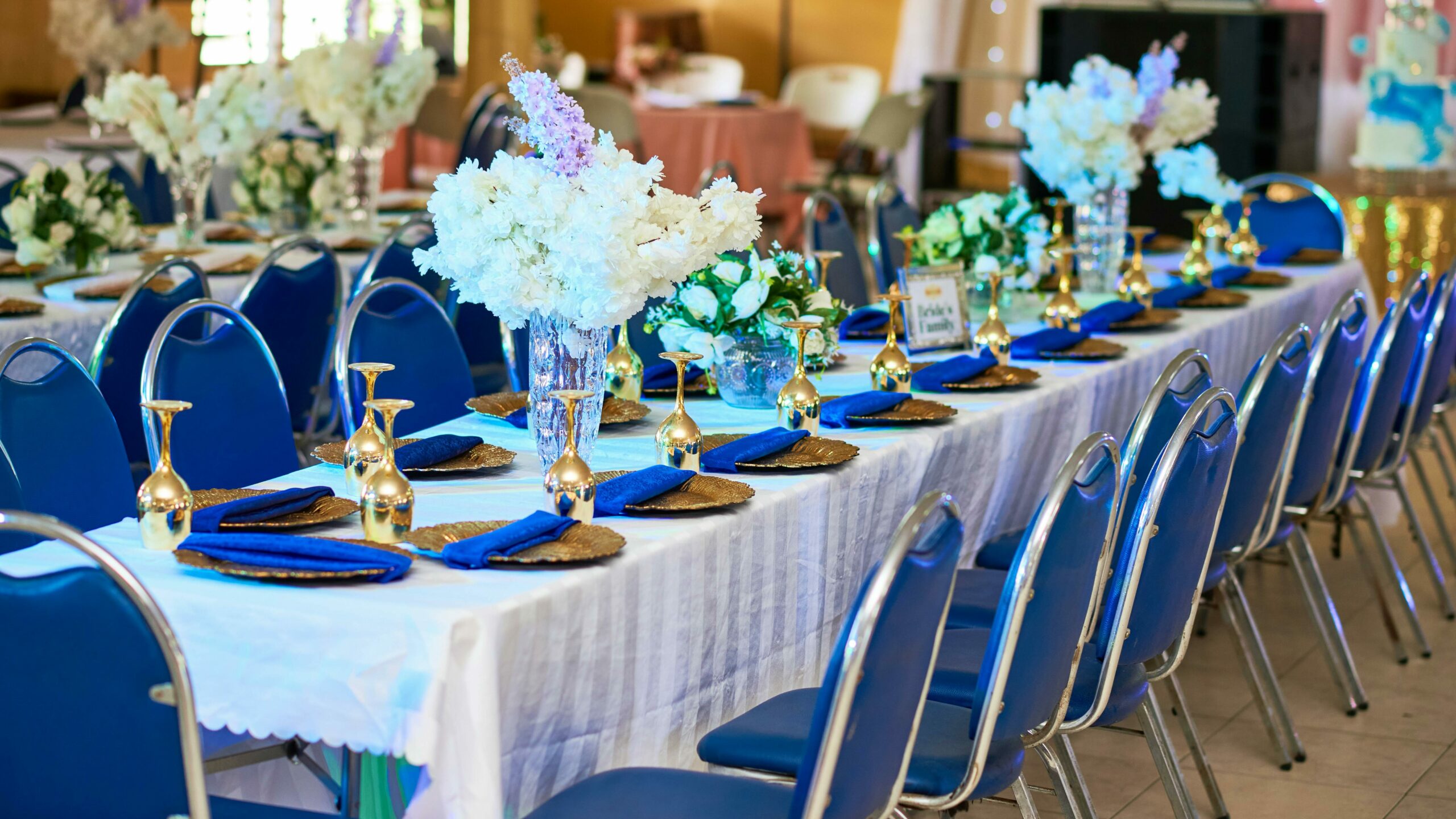 entretien professionnel d'un évènements, ici le mariage. sur l'image se présente une longue table de mariage blanche avec des chaises et décorations bleues
