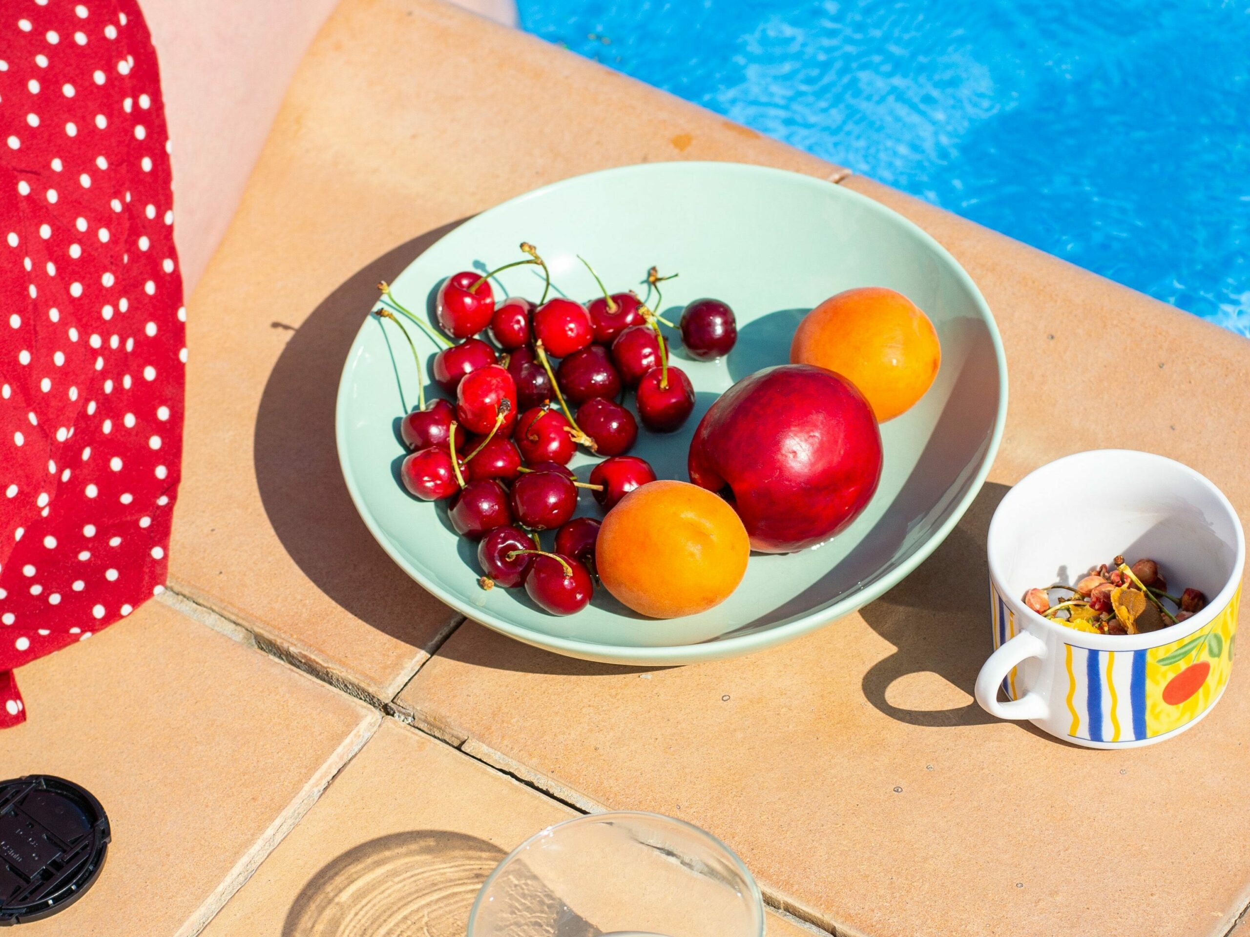 pour prendre soin des personnes âgées pendant la canicule il faut alléger leur alimentation avec ce plat de fruits : cerise, pomme, abricot plus un verre de lait frais au bord de la piscine